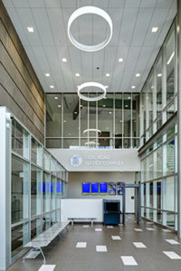 A two-story glass curtain wall stretches the length of the public corridors, creating an abundance of natural light.