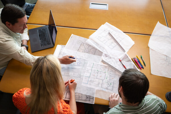 workers reviewing facility assessment plans on a table