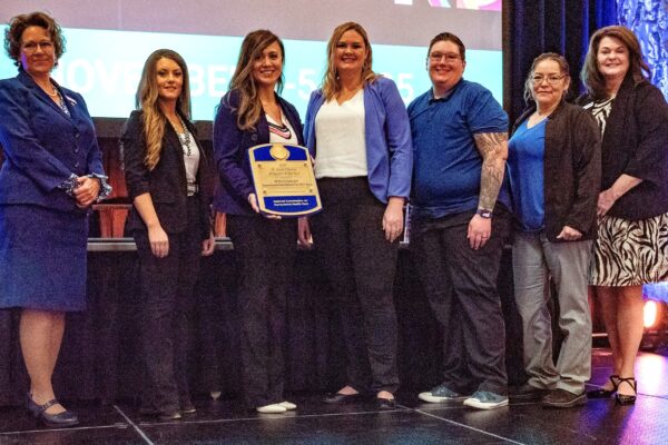 employees of the El Paso County Jail on stage receiving the NCCHC Program of the Year Award