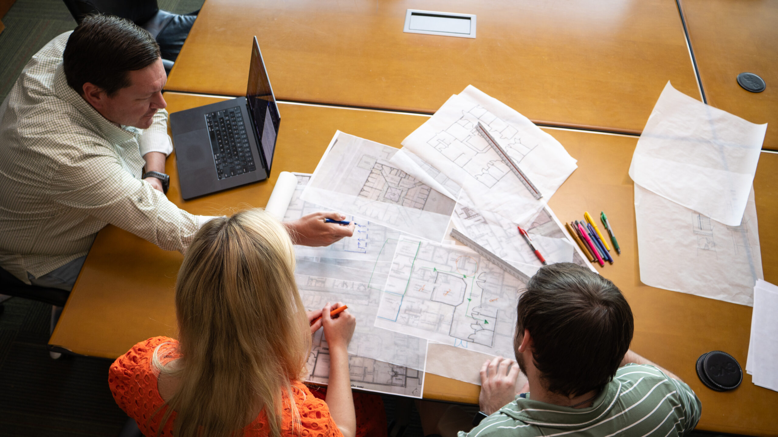 workers reviewing facility assessment plans on a table