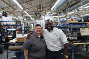 Raquel Bueno and Michael Chike posing in manufacturing facility