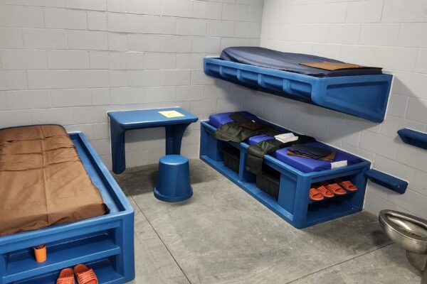 blue plastic bunk beds in a jail cell