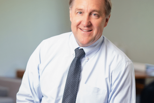 headshot photo of David Mahoney wearing shirt and tie in office setting