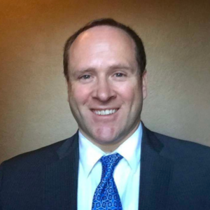 headshot photo of Jon Murad wearing suit and tie