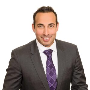 headshot photo of Ram Rajadhyaksha wearing a suit and tie with a white background