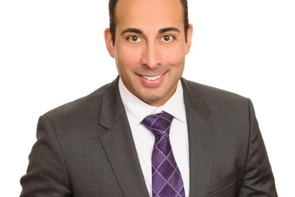 headshot photo of Ram Rajadhyaksha wearing a suit and tie with a white background