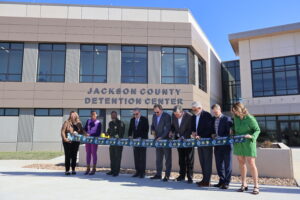 men and women at a ribbon cutting ceremony outside new Jackson Couty Detention Center in Missouri