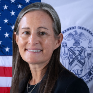 headshot photo of Margaret Egan with American and New York City flags in background