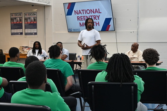 man speaking to incarcerated youth during panel discussion