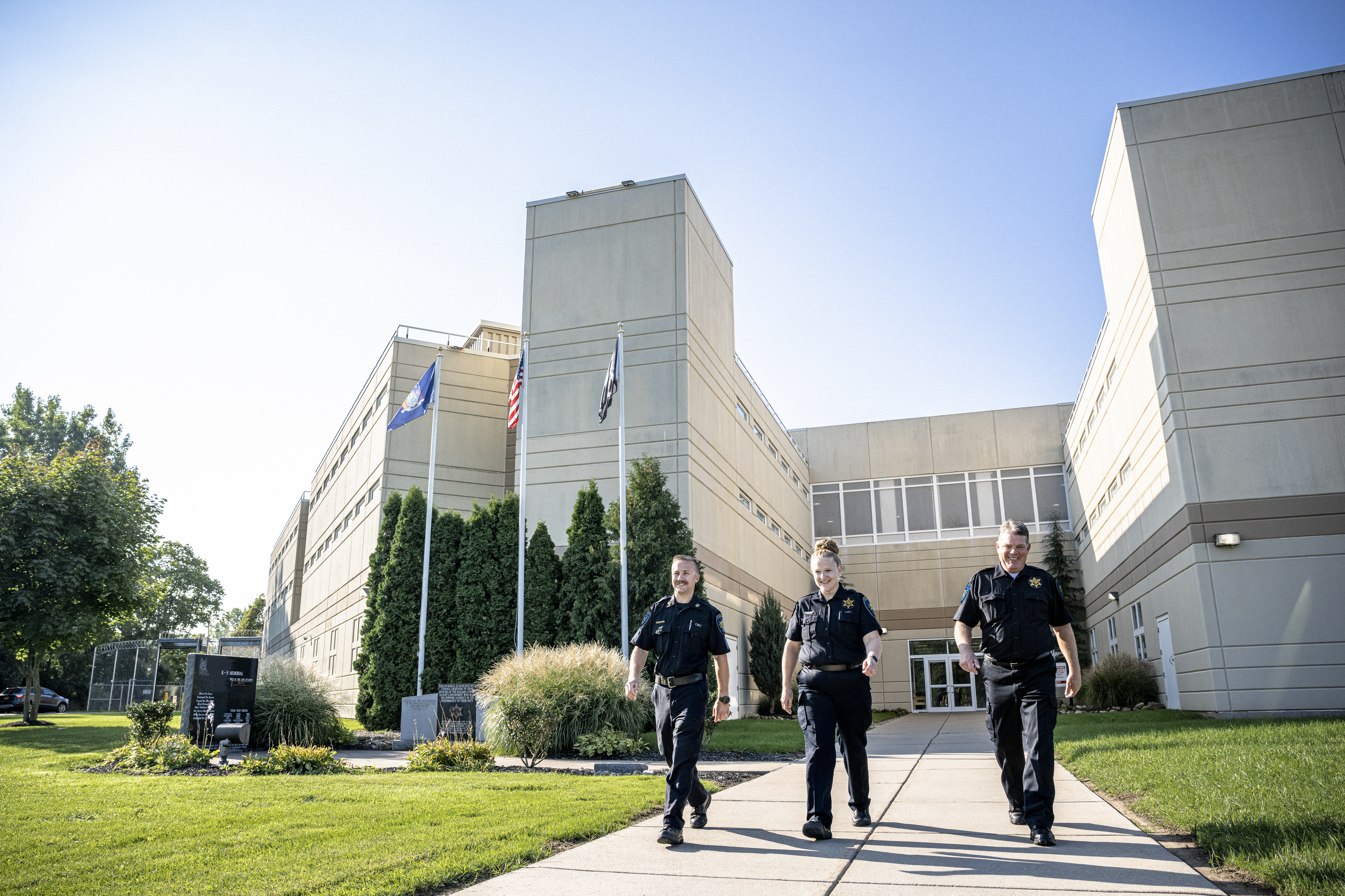officers wearing body cameras walking outside of a correctional facility