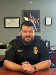 photo of Jon Banville seated at desk wearing correctional uniform