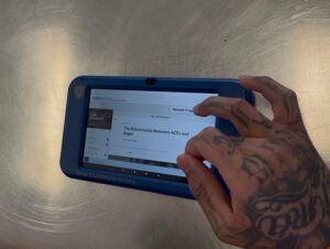 a hand scrolling through tablet programming