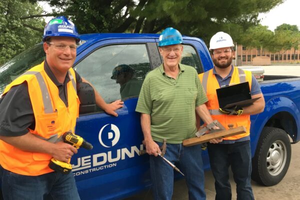 Nick Tuggle with father and grandfather in front of JE Dunn truck