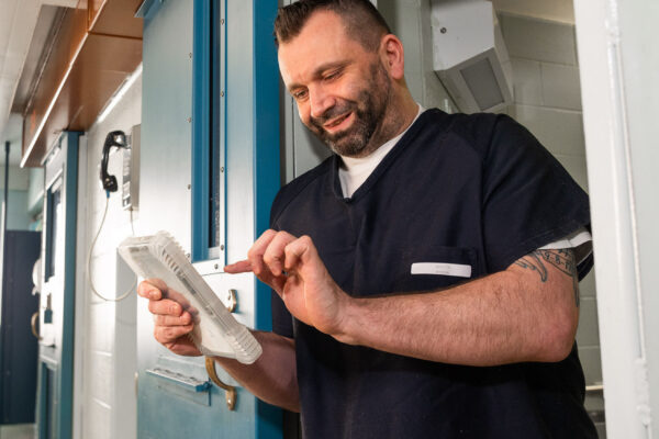 inmate using tablet outside of cell