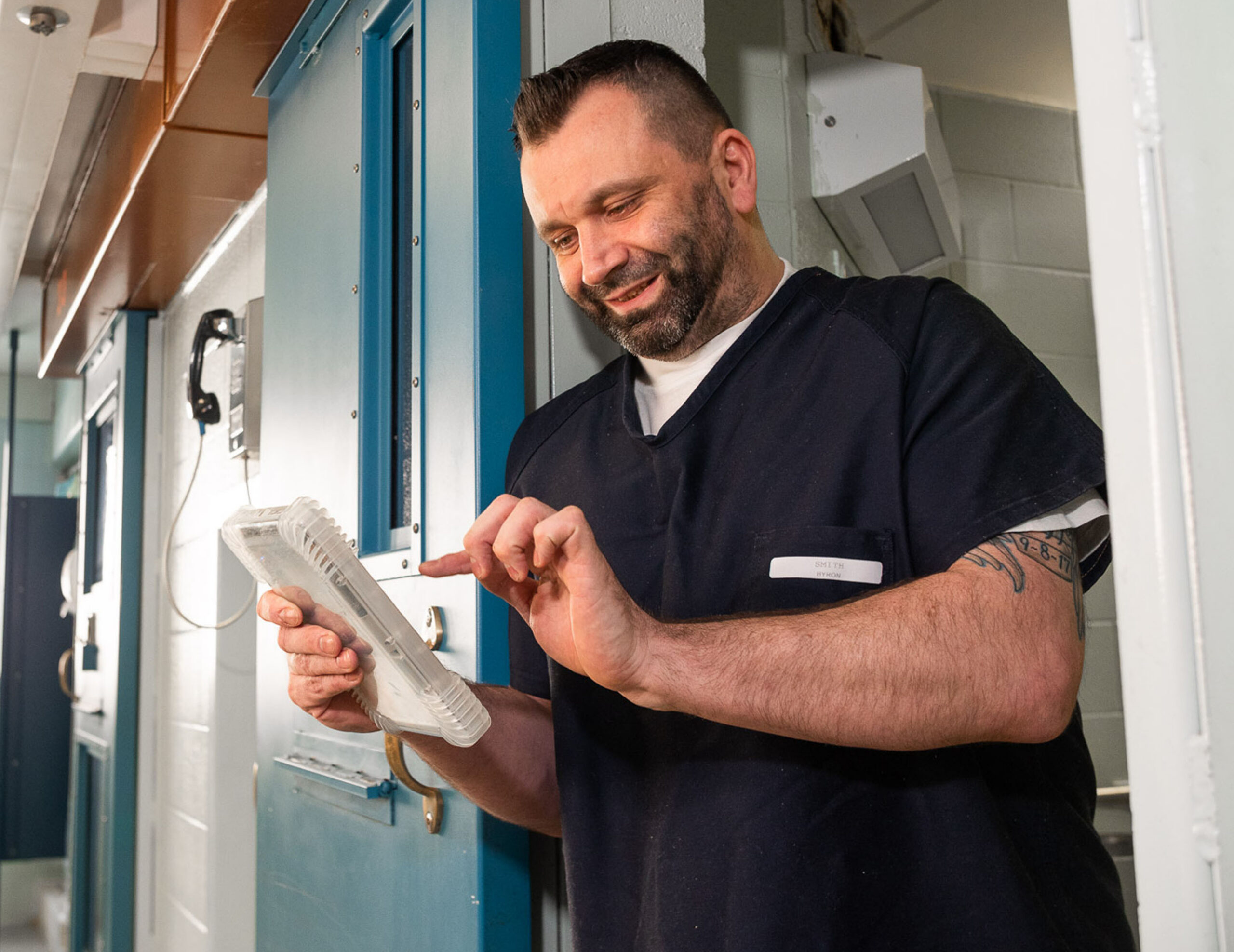 inmate using tablet outside of cell