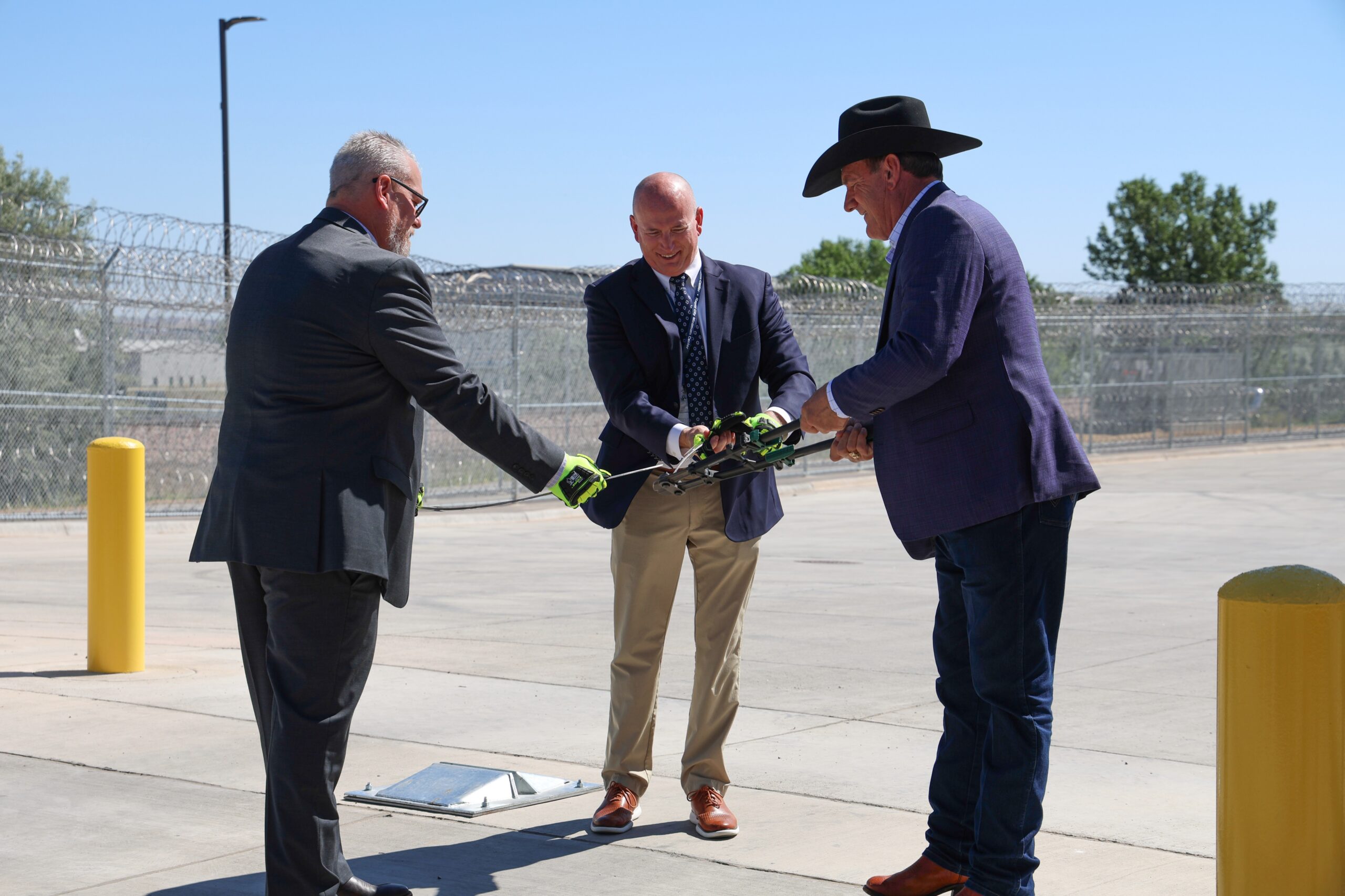 South Dakota Department of Corrections Secretary Nick Lamb, Warden Eric Aldridge and Governor Larry Rhoden cut a piece of wire at the Rapid City Women's Prison