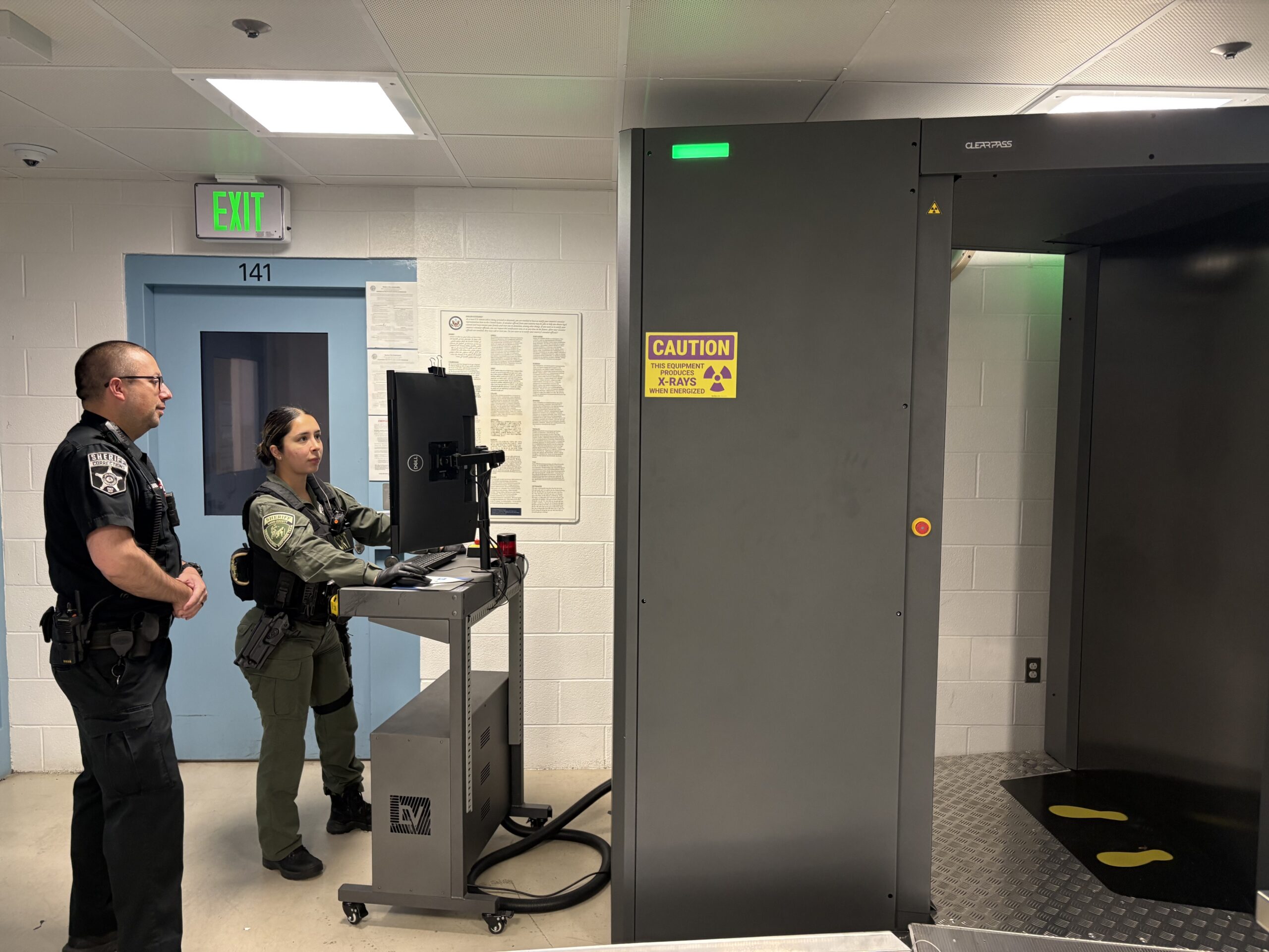 correctional officers using a body scanner